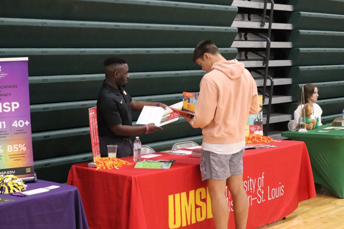 Senior Drake Murrell reads literature with a recruiter from the University of Missouri-St. Louis. 