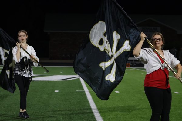 On the left in this photo is Freshman Riley Nevius. Nevius throws her flag up while Sophmore Jennifer Murdock is also throwing her flag up. This took place on October 19th. “This was the last home football game and the colorgaurd really went out, "said freshman Addison Hill.
