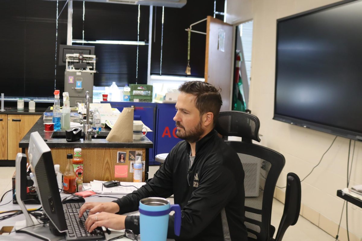 Teacher Daniel Waller types on his computer. Waller teaches physics, chemistry, ecology, and principles of technology.