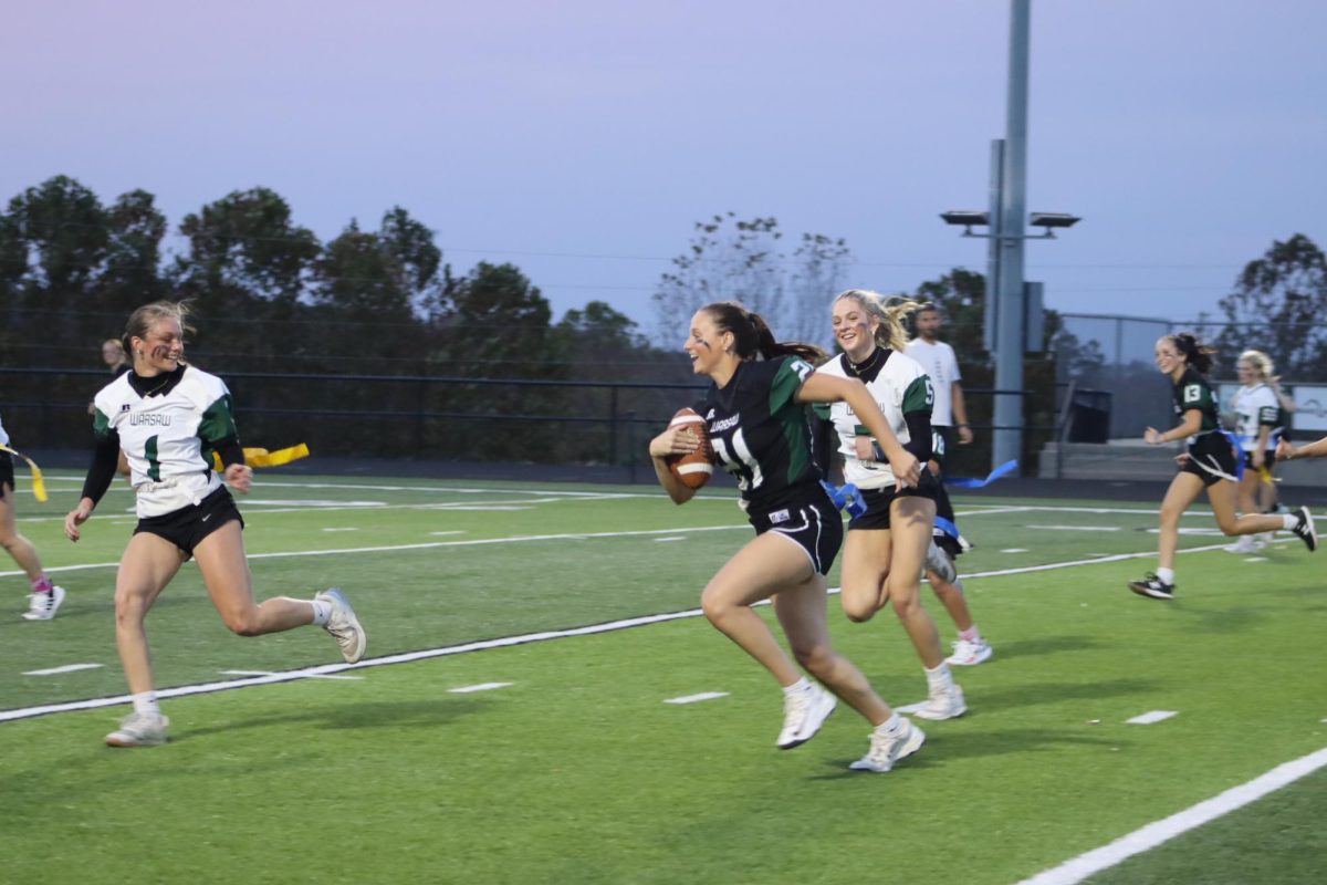 Senior Brylee Brewster runs the ball as junior Tanna Howe and sophomore Maylee Slavens attempt to capture Brewster’s flags. “My favorite part about Powderpuff was probably, whenever Maylee Slavens and I were both running to grab the flag off of Brylee Brewster. I ended up getting it, but Maylee ended up face planting, it was absolutely hilarious,” Howe said. Powderpuff was hosted by the cheer team on Oct. 28.
