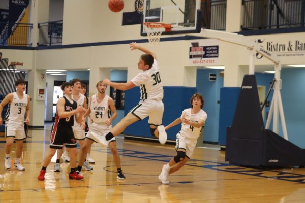 Senior Trent Downing blocks a shot during the varsity game. Wildcats defeated the Santa Fe Chiefs Dec. 21.