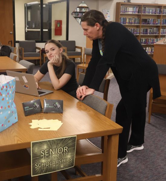 RootEd Advisor Bobbi Swisher gives scholarship guidance to senior Sonia Lasseigne on Feb. 6 during the scholarship application incentive day. Seniors were put in a drawing for a prize for filling out scholarship applications.