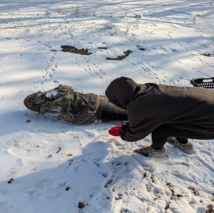 Junior Amy Terry throws snow on freshman Brooke Terry when she is trying to do a snow angel on Jan 8. They both were enjoying the AMI day after doing their work.