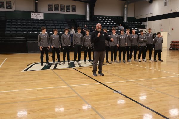 Head basketball Coach Matthew Brownsberger introduces the boys basketball team at the pep assembly on Mar. 3. The pep assembly was held during school before the sectional game to encourage the boys. 