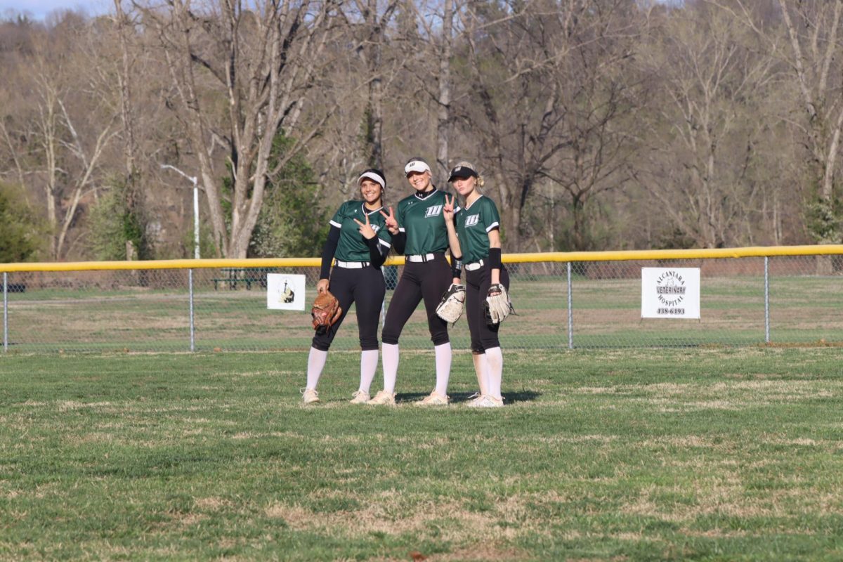 Lady Cats outfield, junior Hailey Ferguson, sophomore Maylee Slavens, and junior Adison Sherrill, meet in center field for a pre-inning pep talk. “Before separating and going back to our positions, we spin in a circle to add some fun in the outfield,” junior left fielder Hailey Ferguson said. 