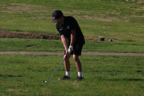 Senior Carter Howell swings at a golf ball during the home meet versus Lincoln on April 15, 2025. Howell has been apart of the team since his freshman year.