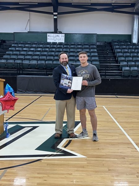 Drake Murrell receives his appointment in to the U.S. Naval Academy from Naval Information Officer Lee Gilgour in March.