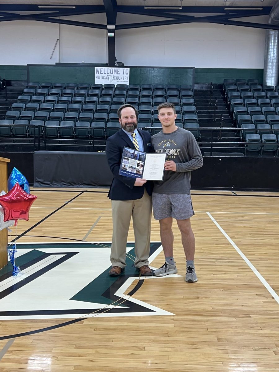 Drake Murrell receives his appointment in to the U.S. Naval Academy from Naval Information Officer Lee Gilgour in March.