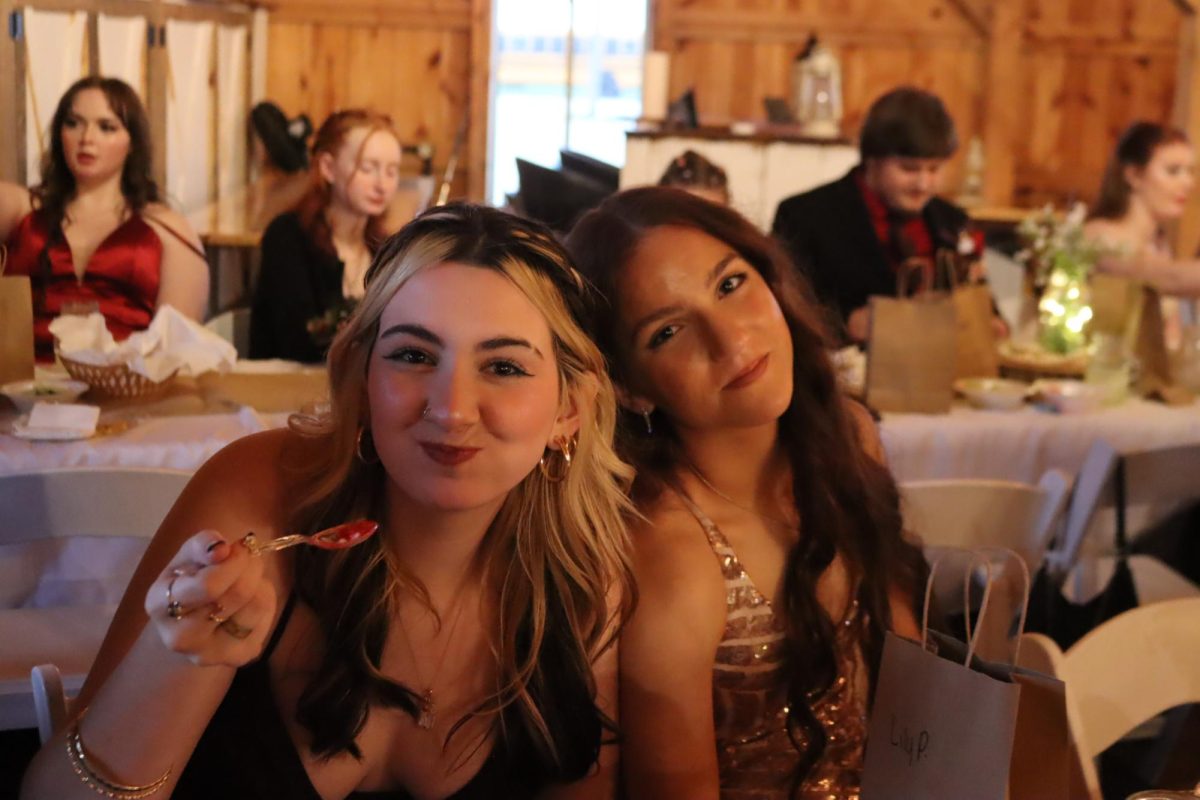 Junior Vincenza Parsi and sophomore Lillianna Perez pose while eating cheesecake at the dance. Parsi loved getting to experience prom with her younger cousin. 