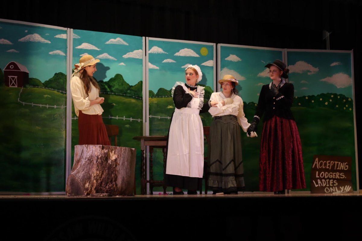 Seniors Aleah Minks (Nellie Lovelace), Hayley Boly (Fleurette), Sarah Jessica Sherlin (Leonie), and Eliana Jensen (Mrs. Upson Asterbilt) perform in the scene where Mrs. Upson Asterbilt brought her daughter, Leonie, and their french maid, Fleurette, to stay at Nellie’s farm house and were opposed to the farm animals running about.