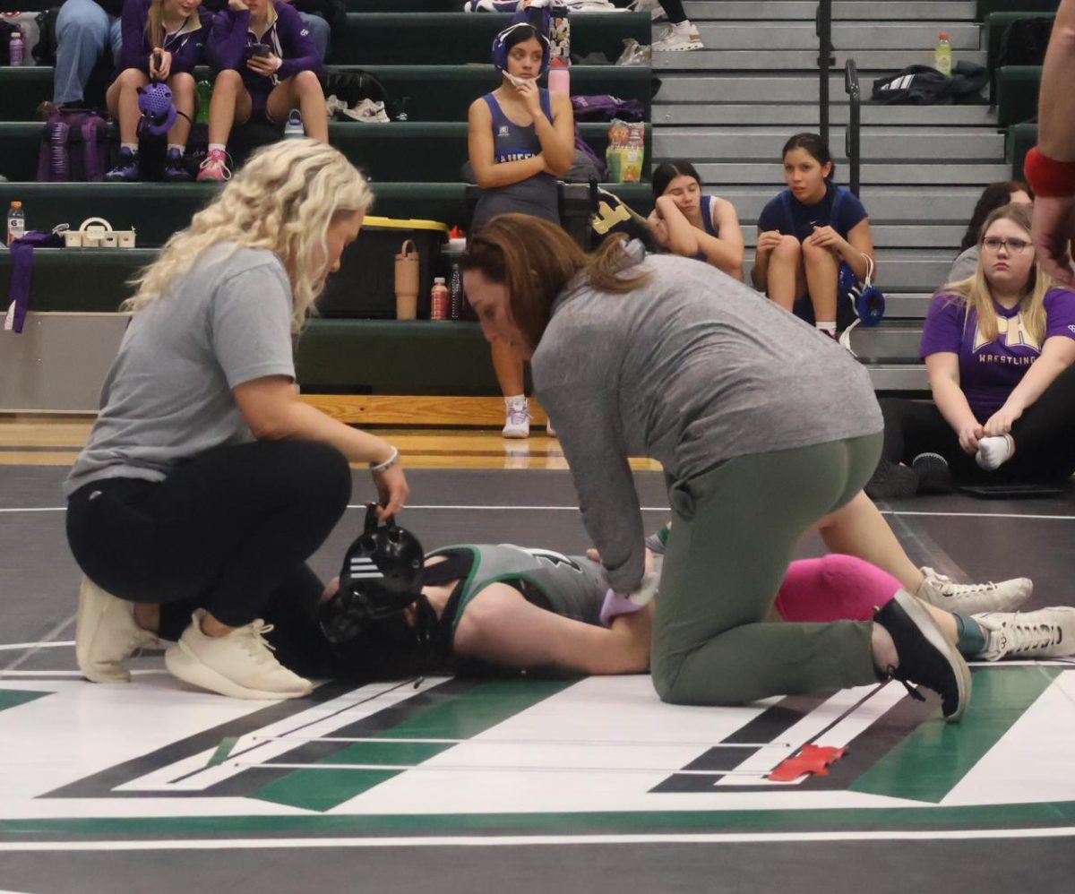 Athletic trainer Lisha Douglas helps sophomore Emmersyn Miskell when she gets injured during her first match at the Warsaw Tournament on Jan. 16. Lisha was present all three days of the tournament. 